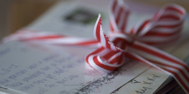 Post cards and letters written with love and tied with red and white striped ribbon.