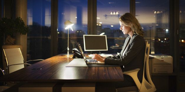 Mature business woman working late in front of a laptop.