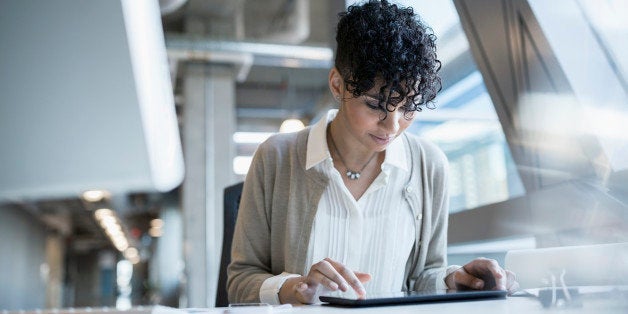 Businesswoman using digital tablet at office desk