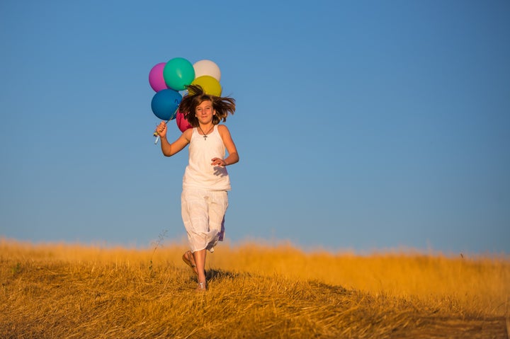 girl running with balloons