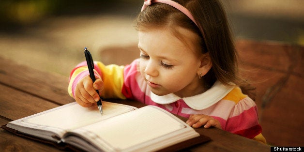 a little girl learning to write