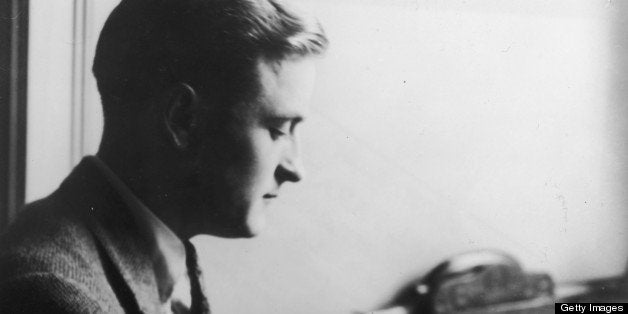 Profile view of American author F(rancis) Scott (Key) Fitzgerald (1896 - 1940) reading a book while sitting at a desk. (Photo by Hulton Archive/Getty Images)