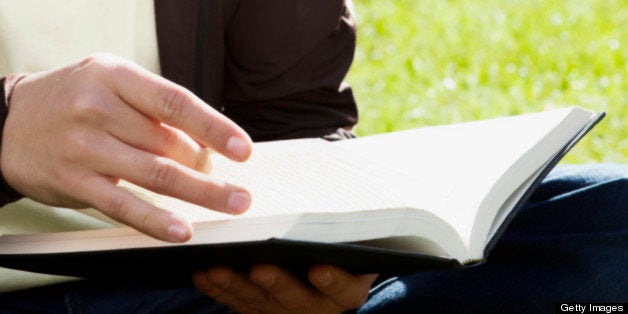 Man holding a book in a park