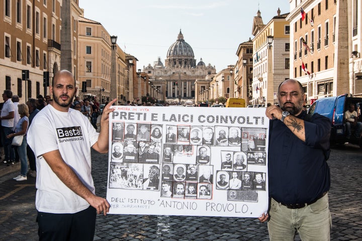 Protestors in Rome hold a banner with pictures of priests accused of abusing hearing impaired children at the Antonio Provolo