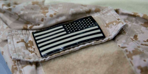 In this Sept. 5, 2014 photo provided by the National September 11 Memorial and Museum, a detail of the fatigue shirt showing an American flag emblem which worn by the U.S. Navy SEAL during the mission to capture Osama bin Laden, is seen in a case at the museum in New York. The shirt and other items from the raid will be introduced to the public on Sunday, Sept. 7.(AP Photo/National September 11 Memorial and Museum, Jin Lee)