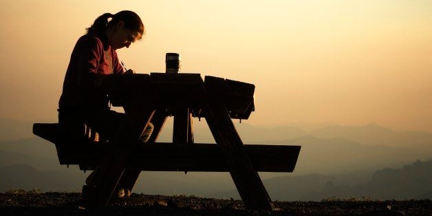 Woman sitting at a picnic table.