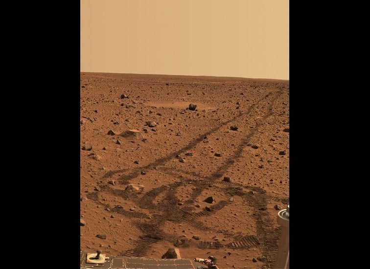 While driving over the reddish rocks and soils of Mars, the rover's wheels dig below the thin
dusty layer and reveal darker,