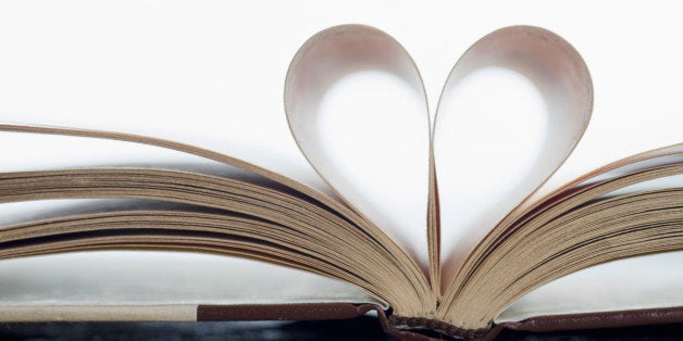 Close-up of book on beach with pages folded in heart shape