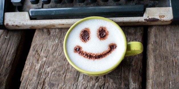 Happy coffee cup and Vintage typewriter on wooden background.