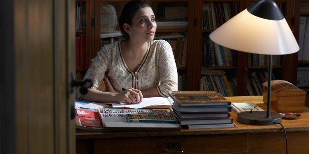 Woman writing at desk in home office