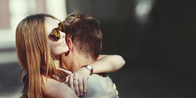 Happy teen couple embracing at street. Great relationships.