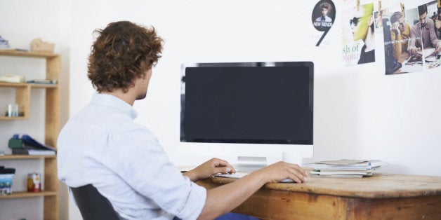 Rearview shot of a young man working on a computer