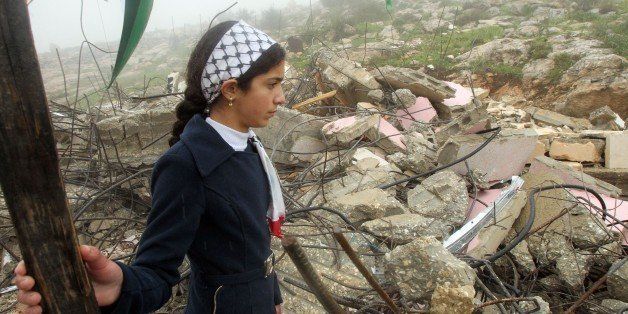 The daughter of Raid Masalmeh, a Palestinian man who stabbed two Israelis to death at an office building and car park in Tel Aviv, looks at the debris of her family home after it was demolished near the West Bank village of Dura on February 23, 2016.Israel has destroyed the homes of two Palestinians accused of separate attacks that left five people dead, the army said, the latest in a series of punitive demolitions that have drawn criticism from rights groups.The overnight demolitions west of Hebron targeted the homes of two men said to be behind November 19 knife and car-ramming attacks in Israel's commercial capital Tel Aviv and at a junction in the occupied West Bank. / AFP / HAZEM BADER (Photo credit should read HAZEM BADER/AFP/Getty Images)