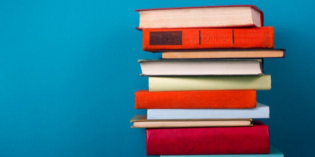 Stack of colorful books, grungy blue background, free copy space Vintage old hardback books on wooden shelf on the deck table