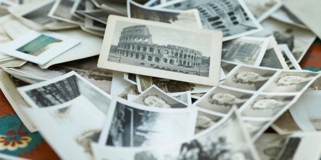 Various black and white photographs in pile on table