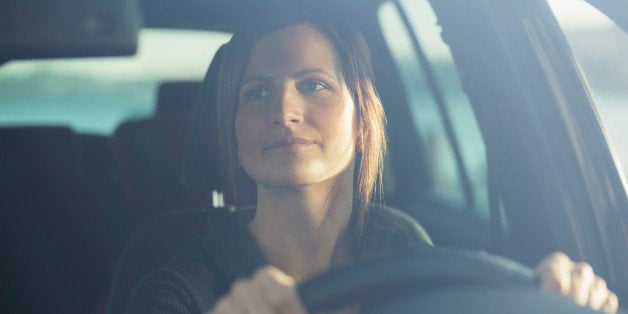 Young businesswoman driving car