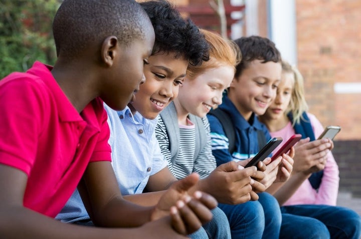 <p>Cellphones carry certain risks for elementary school students. <a rel="nofollow" href="https://www.shutterstock.com/image-photo/pupils-using-mobile-phone-elementary-school-1088478797?src=vi7mDrXCq1nv_16ZMpqFXg-1-6" target="_blank">Rido/www.shutterstock.com</a></p>