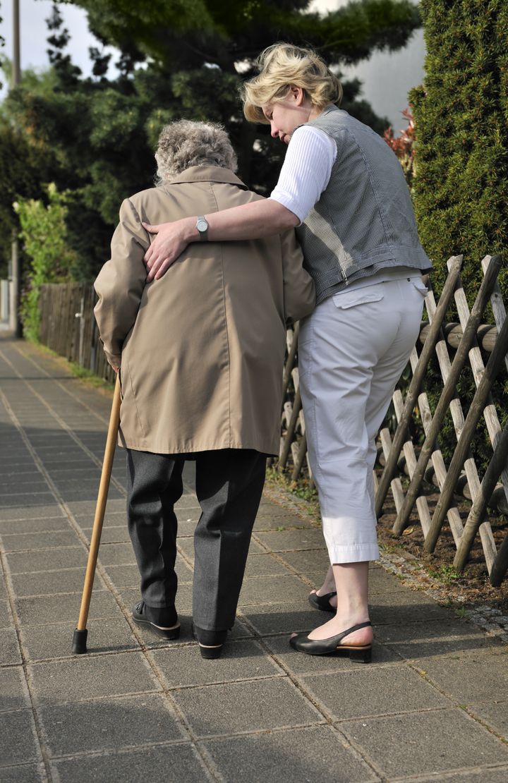 Senior woman walking with the help of a daughter