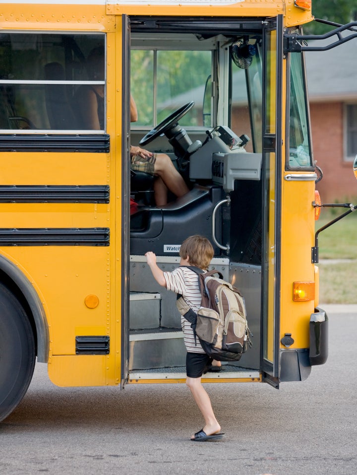 little boy getting on bus