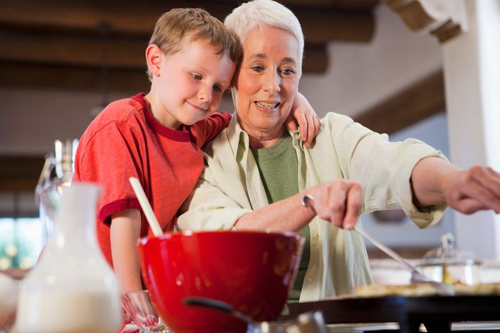 Caucasian grandmother and grandson cooking together