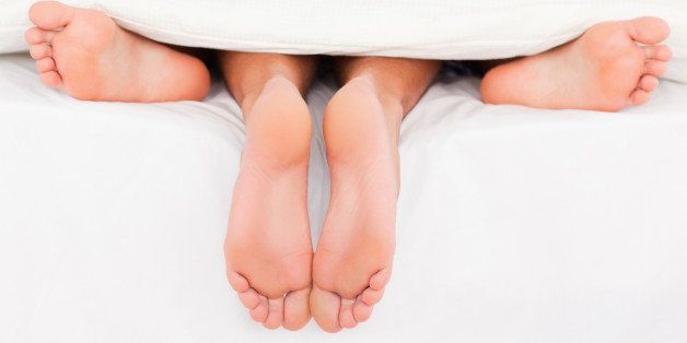 Pairs of feet in a bed