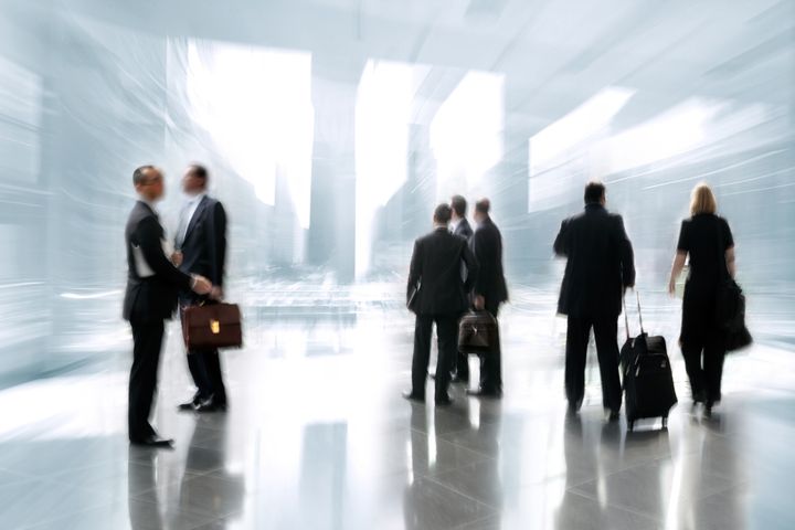 blurred abstract image of a business people activity standing in the lobby, backlit light from a window and intentional blur and tint