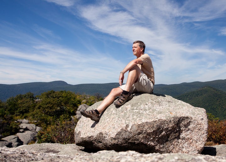 Senior hiker looks over valley in the Shenandoah on a climb of Old Rag