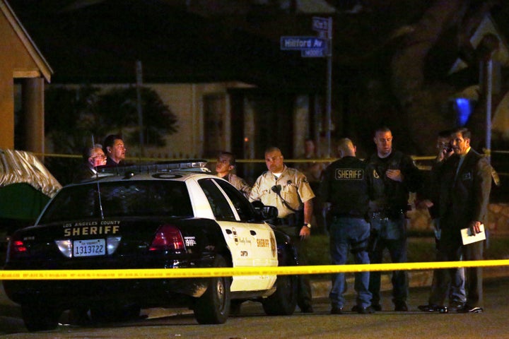 Los Angeles County sheriff's deputies and investigators stand near the scene where Terry Carter was killed in a hit-and-run crash involving Marion "Suge" Knight in 2015.