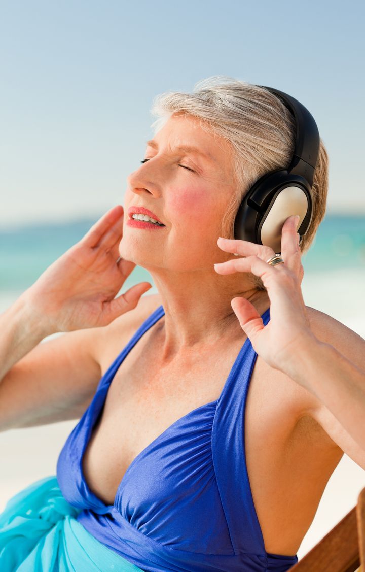 senior woman listening to music ...