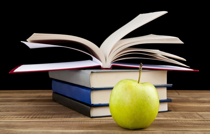 apple and books on wooden table