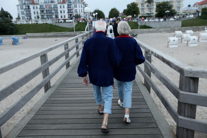 KUEHLUNGSBORN, GERMANY - AUGUST 13: An elderly couple walk on a pier at the beach at the Baltic Sea on August 13, 2010 in Kuehlungsborn, Germany. The Baltic Sea coastline, with its long sand beaches, is a popular holiday destination. (Photo by Sean Gallup/Getty Images)