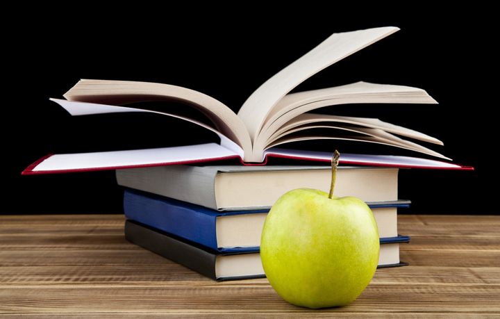 apple and books on wooden table