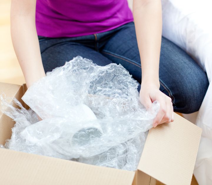 Young woman unpacking box in the living-room