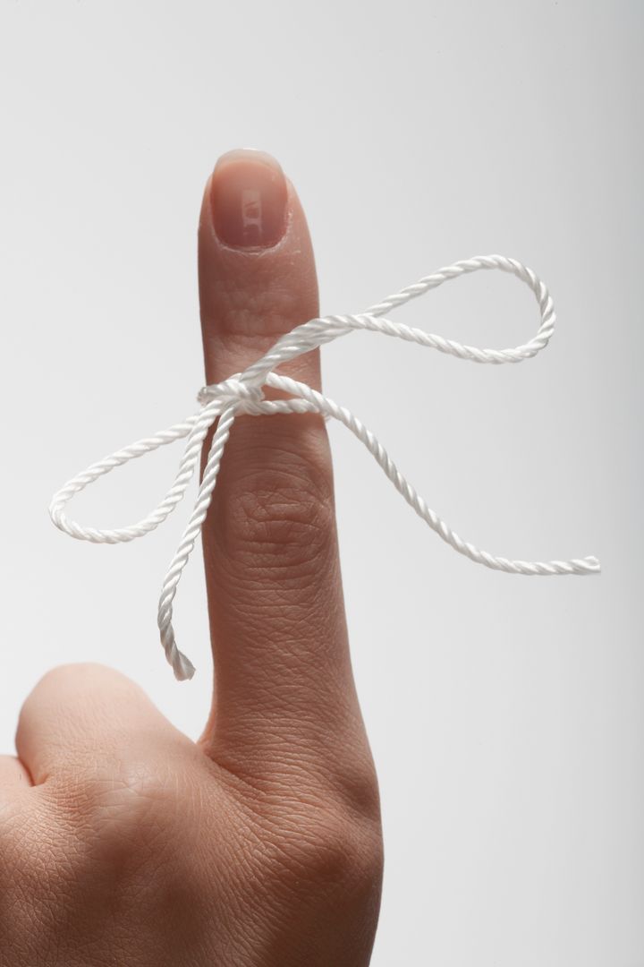 String tied on woman's index finger (close-up)