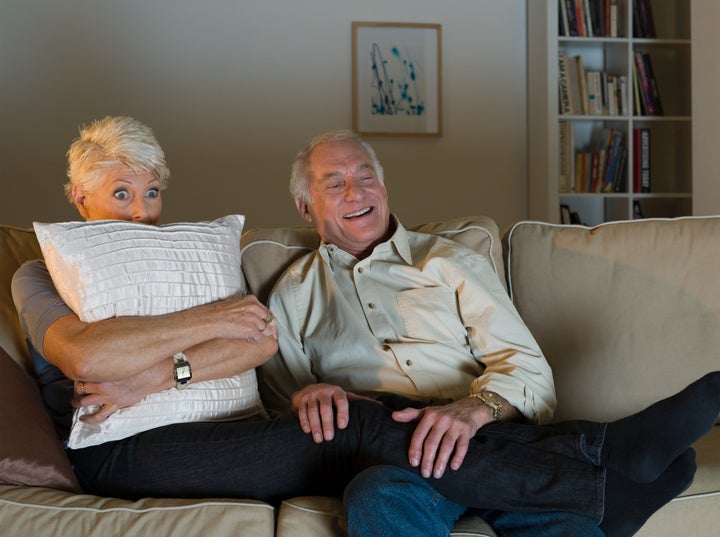 A senior couple watching tv