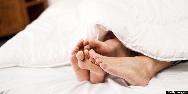 Close-up of an old couple's feet on bed