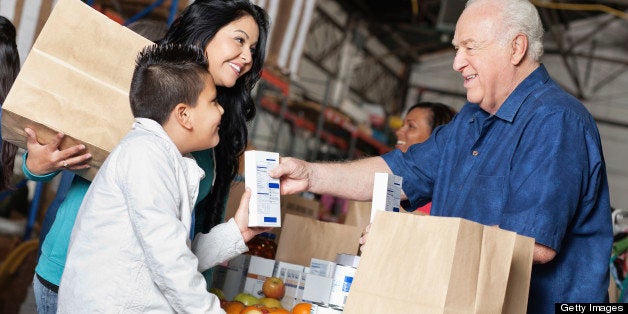 Young boy and mother donating food at a pantry.