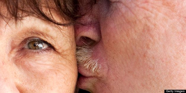 Older man kissing his wife on the cheek