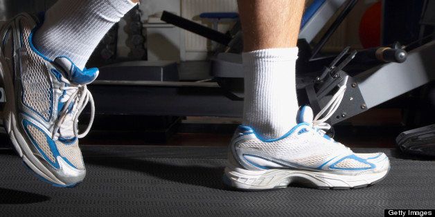 Man's feet on a treadmill in a gym