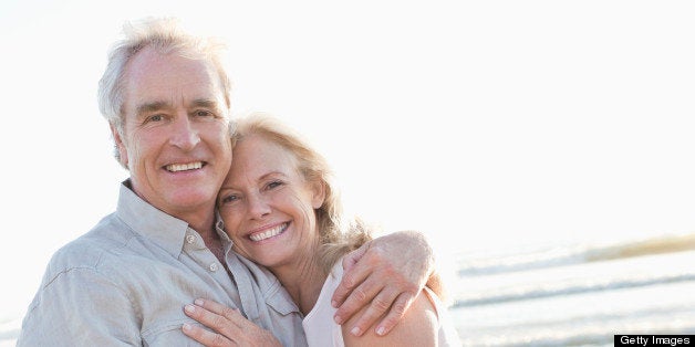 Portrait of a cheerful couple hugging on beach