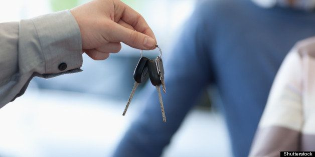 car dealer giving keys to a...