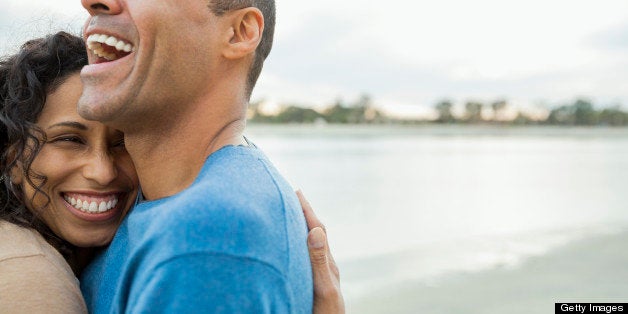 Laughing mature couple embracing on beach