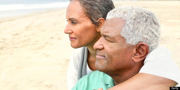 A happy senior couple is sharing a romantic moment on the beach.