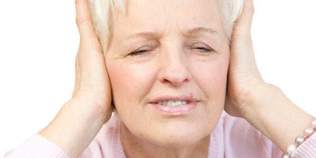 Old woman covering her ears with both hands