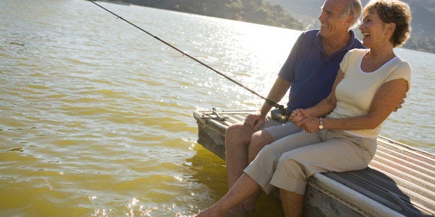 Mature couple by lake fishing