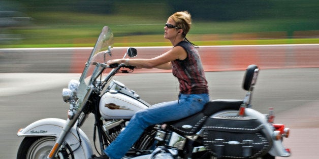 UNITED STATES - SEPTEMBER 07: A woman rides her Harley-Davidson motorcycle from the parking lot at the A.D. Farrow Harley-Davidson dealership Friday, Sept. 7, 2007, in Sunbury, Ohio, U.S. Harley-Davidson Inc., the biggest U.S. motorcycle maker, slashed its forecast for profit and shipments to dealers after U.S. sales decreased last month. (Photo by Gary Gardiner/Bloomberg via Getty Images)