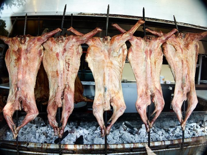 Roast goat meat hangs above hot coals in Monterrey, Mexico.