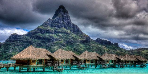 View On BlackSome of the bungalows at the Thalasso Spa on Bora Bora with Mount Otemanu in the background.