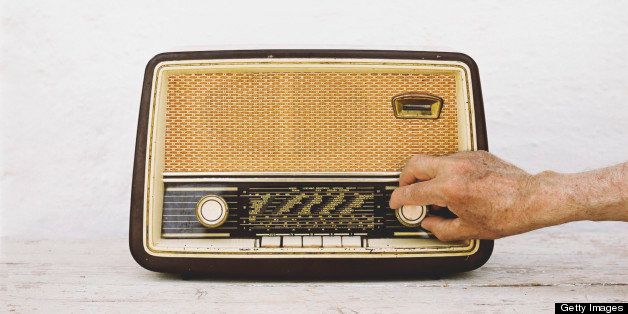 Man's hands on old radio