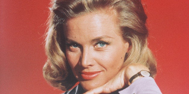 Honor Blackman, British actress, posing in a studio portrait, aginst a red background, issued as publicity for the film, 'Goldfinger', circa 1964. The James Bond film, directed by Guy Mailton, starred Blackman as 'Pussy Galore'. (Photo by Silver Screen Collection/Getty Images)